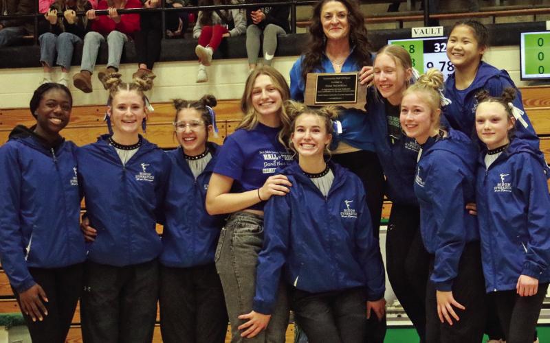 Hot Springs gymnastics coach Dana Nachtigall poses with her team at this past weekend’s State Gymnastic Meet after being presented a plaque inducting her into the S.D. Gymnastics Coaches Association Hall of Fame. Photo by Brett Nachtigall/Fall River County Herald-Star