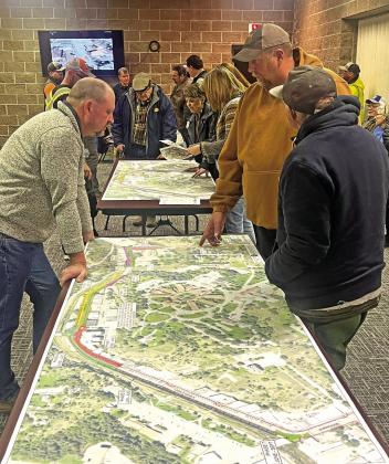 Personnel with the South Dakota Department of Transportation and members of the public discuss the Hot Springs Urban Reconstruction project over large maps of the project in the Mueller Center Annex during an open house event last Wednesday, March 6. Photo by Brett Nachtigall/Fall River County Herald-Star