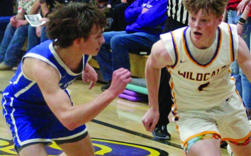 Hot Springs senior Braden Peterson defends a Custer player in front of former Hot Springs Bison athlete Joe Beehler who was refereeing the game last Thursday night in Custer. Photo by Jason Ferguson/Custer County Chronicle