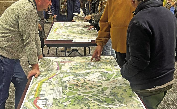Personnel with the South Dakota Department of Transportation and members of the public discuss the Hot Springs Urban Reconstruction project over large maps of the project in the Mueller Center Annex during an open house event last Wednesday, March 6. Photo by Brett Nachtigall/Fall River County Herald-Star